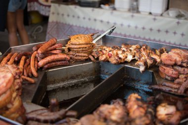 Şef ızgarada et hazırlıyor, dışarıda yemek festivali, yemek kamyonu, brunch ya da catering etkinliği sırasında. Domuz bifteği, tavuk göğsü, sosis, yüksek protein, sağlıksız ve şişman et parçaları.