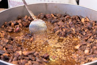 Sağlıksız, yağlı, yağlı, et dilimleri karışımı, fast food festivalinde büyük bir tencerede kızarma. Geleneksel Romanya yemeği olan 