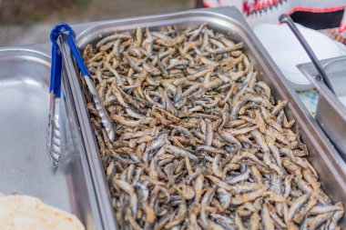 Pazarda ya da yemek festivalinde kızarmış küçük balıklar, yemek kamyonu, Asya pazarı. Canlı yemek istasyonu. Kızarmış balık, deniz ürünleri, sokak yemekleri.