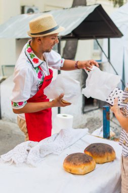 Bükreş, Romanya, 1 Eylül 2019: Geleneksel kıyafet giymiş bir adam ekmek hazırlıyor. Ahşap taş fırınında taze pişmiş ekmek.