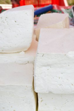 Süpermarketteki şarküteride satılık bitkilerle tatlandırılmış çeşitli peynir tekerleri. Yemek festivalinde Romanya 'nın geleneksel yumuşak ve sert peynir çeşitleri tezgahın üzerinde