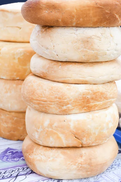 A variety of wheels of cheese seasoned with herbs for sale at the deli counter in the supermarket. Romanian traditional assortment of soft and hard cheeses on the counter top during food festival