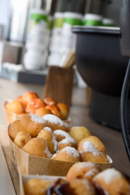 Karnaval veya fast food festivali sırasında, koyu ve beyaz çikolata sosu ve ahududu veya çilek kırmızısı sosu, şemsiyeler ve renkli konseptle kaplı taze yuvarlak küçük çörekler. Mutlu yıllar.