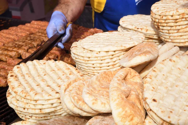 新鮮なピタのフラットブレッドの山 グルテンフリーレバノン料理やギリシャ料理 焼きまたはオーブン焼き 屋外イベント中の販売のためのフードフェスティバル — ストック写真