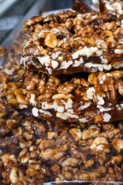 Satılık bir kasede granola bar. Sağlıklı tatlı atıştırmalığı. Mısır gevreği, fındık, meyve ve böğürtlen ile beyaz taş bir masada. Üst görünüm ve kapatma