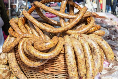 Çeşitli et ürünleri, sosisler, sucuk, karanlık bir masada baharatlar. Yukarıdan bak. Farklı baharatlı baharatlı sığır eti ve domuz sosisi çeşitleri. Sokak yemekleri, fast food çeşitleri.