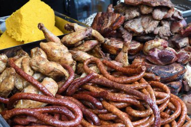 Şef piknik ya da yemek etkinliği sırasında et pişiriyor. Etlerin karışımı: sosis, domuz eti, tavuk, kuzu, koyun, sardalya, kızarmış veya ızgara, sağlıksız protein konsepti. Yağlı yiyecekler, kanserli yiyecekler