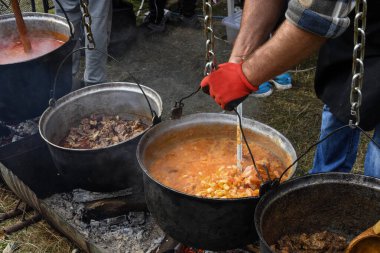 Kamp ateşi sırasında yemek pişiren çok büyük bir kazan, yemek festivali sırasında hazırlanan büyük kaplar. Ateşin üzerinde asılı duran bir turist potası. Ateşin üstünde tencerede yemek pişirmek. Kamp kavramı