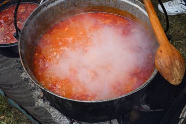 Kamp ateşi sırasında yemek pişiren çok büyük bir kazan, yemek festivali sırasında hazırlanan büyük kaplar. Ateşin üzerinde asılı duran bir turist potası. Ateşin üstünde tencerede yemek pişirmek. Kamp kavramı