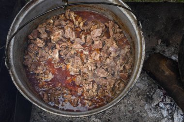 Kamp ateşi sırasında yemek pişiren çok büyük bir kazan, yemek festivali sırasında hazırlanan büyük kaplar. Ateşin üzerinde asılı duran bir turist potası. Ateşin üstünde tencerede yemek pişirmek. Kamp kavramı