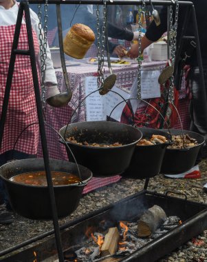 Kamp ateşi sırasında yemek pişiren çok büyük bir kazan, yemek festivali sırasında hazırlanan büyük kaplar. Ateşin üzerinde asılı duran bir turist potası. Ateşin üstünde tencerede yemek pişirmek. Kamp kavramı