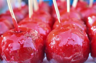 Çiftçi pazarında ya da kasaba fuarında satılmak üzere çubuklarda satılan tatlı, kırmızı şekerli elma şekerlemeleri. Şükran Günü ve Cadılar Bayramı ev yapımı kırmızı karamel jöleli elma şekerlemesi.