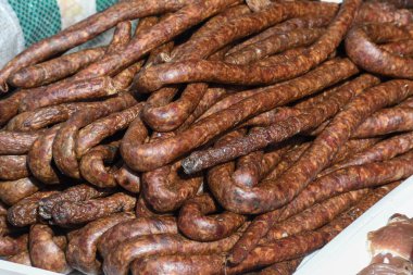 Çeşitli et ürünleri, sosisler, sucuk, karanlık bir masada baharatlar. Yukarıdan bak. Farklı baharatlı baharatlı sığır eti ve domuz sosisi çeşitleri. Sokak yemekleri, fast food çeşitleri.