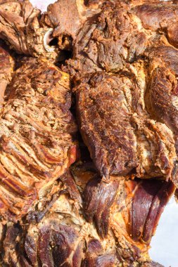 Çeşitli et ürünleri, sosisler, sucuk, karanlık bir masada baharatlar. Yukarıdan bak. Farklı baharatlı baharatlı sığır eti ve domuz sosisi çeşitleri. Sokak yemekleri, fast food çeşitleri.