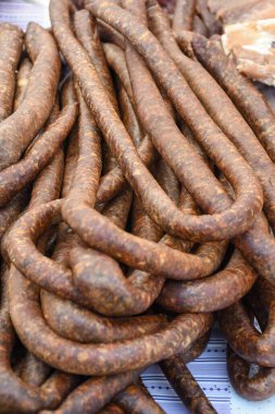 Çeşitli et ürünleri, sosisler, sucuk, karanlık bir masada baharatlar. Yukarıdan bak. Farklı baharatlı baharatlı sığır eti ve domuz sosisi çeşitleri. Sokak yemekleri, fast food çeşitleri.