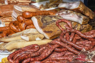 Çeşitli et ürünleri, sosisler, sucuk, karanlık bir masada baharatlar. Yukarıdan bak. Farklı baharatlı baharatlı sığır eti ve domuz sosisi çeşitleri. Sokak yemekleri, fast food çeşitleri.