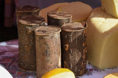 Branza de burduf, Transilvania 'nın güneyinden geleneksel koyun sütü peyniri, Romanya özel peyniri, sarı yuvarlak keçi peyniri topları ev yapımı, ağaç kabuğu örtüsü, renkli peçete