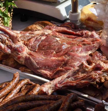 Çeşitli et ürünleri, sosisler, sucuk, karanlık bir masada baharatlar. Yukarıdan bak. Farklı baharatlı baharatlı sığır eti ve domuz sosisi çeşitleri. Sokak yemekleri, fast food çeşitleri.