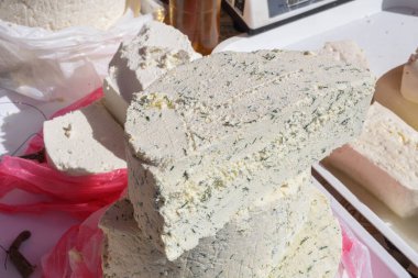 Yemek festivali sırasında tezgahta satılmak üzere dereotlu ve baharatlı dilimlenmiş peynir. Geleneksel süt ürünleri taze inek ya da keçi sütünden yapılır, aperatif olarak sunulur, kare şeklinde peynir kesilir.