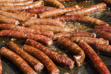 Şef piknik ya da yemek etkinliği sırasında et pişiriyor. Etlerin karışımı: sosis, domuz eti, tavuk, kuzu, koyun, sardalya, kızarmış veya ızgara, sağlıksız protein konsepti. Yağlı yiyecekler, kanserli yiyecekler