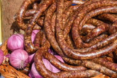 Çeşitli et ürünleri, sosisler, sucuk, karanlık bir masada baharatlar. Yukarıdan bak. Farklı baharatlı baharatlı sığır eti ve domuz sosisi çeşitleri. Sokak yemekleri, fast food çeşitleri.