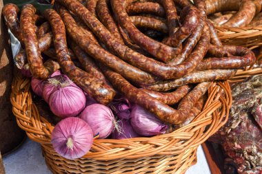Çeşitli et ürünleri, sosisler, sucuk, karanlık bir masada baharatlar. Yukarıdan bak. Farklı baharatlı baharatlı sığır eti ve domuz sosisi çeşitleri. Sokak yemekleri, fast food çeşitleri.