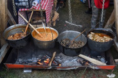 Kamp ateşi sırasında yemek pişiren çok büyük bir kazan, yemek festivali sırasında hazırlanan büyük kaplar. Ateşin üzerinde asılı duran bir turist potası. Ateşin üstünde tencerede yemek pişirmek. Kamp kavramı