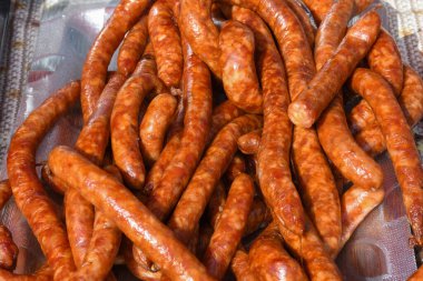 Çeşitli et ürünleri, sosisler, sucuk, karanlık bir masada baharatlar. Yukarıdan bak. Farklı baharatlı baharatlı sığır eti ve domuz sosisi çeşitleri. Sokak yemekleri, fast food çeşitleri.