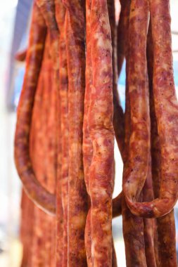 Çeşitli et ürünleri, sosisler, sucuk, karanlık bir masada baharatlar. Yukarıdan bak. Farklı baharatlı baharatlı sığır eti ve domuz sosisi çeşitleri. Sokak yemekleri, fast food çeşitleri.