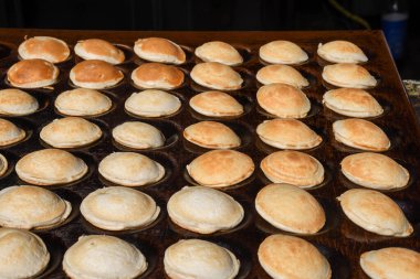 Tipik Hollandalı poffertjes - sokak yemekleri festivali sırasında ağır dökme demir bir tavada pişirilen küçük krepler, açık hava etkinliği, çikolata sosu ve şekerle servis edilen geleneksel tatlı