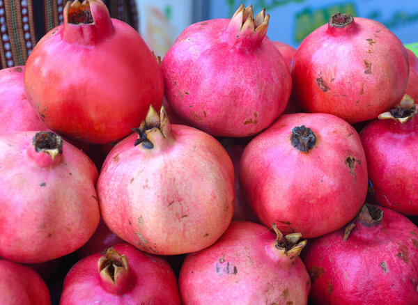 Pomegranate fruit stack pile on counter top for sale during food market festival