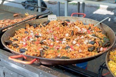 Otel brunch büfesi sırasında havuzun yanındaki bahçede büyük tavada pişen taze deniz mahsullü makarna. Taze Yemek Büfesi Yemek Yemeği Paylaşım Partisi Konsepti