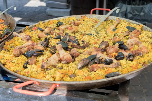 Seafood paella cooked in a large pan wok, street food festival. Mexican fiesta national day dish specialty. Live cooking station. Fresh Food Buffet Brunch Catering Dining Eating Party Sharing Concept