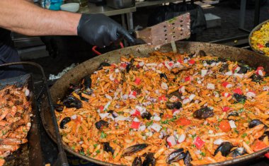 Otel brunch büfesi sırasında havuzun yanındaki bahçede büyük tavada pişen taze deniz mahsullü makarna. Taze Yemek Büfesi Yemek Yemeği Paylaşım Partisi Konsepti