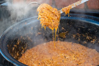 Geleneksel lahana güveci, büyük bir tencerede pişirme, sokak yemekleri festivali, acı biber ve baharat. Yemek Büfesi Yemeği Yemeği Paylaşım Partisi