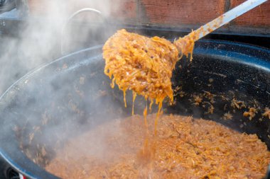 Geleneksel lahana güveci, büyük bir tencerede pişirme, sokak yemekleri festivali, acı biber ve baharat. Yemek Büfesi Yemeği Yemeği Paylaşım Partisi