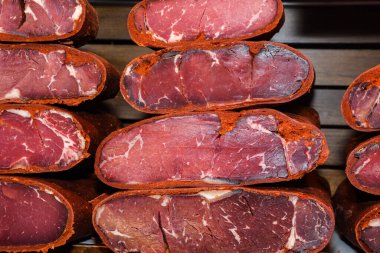 Türk pastırması dilimleri. Pastirma 'yı doğramak ve doğramak, Türk havası kurutulmuş et. Biberli biftekli pastırma dilimleri ve Grand Bazaar 'da renkli biber taneleri.