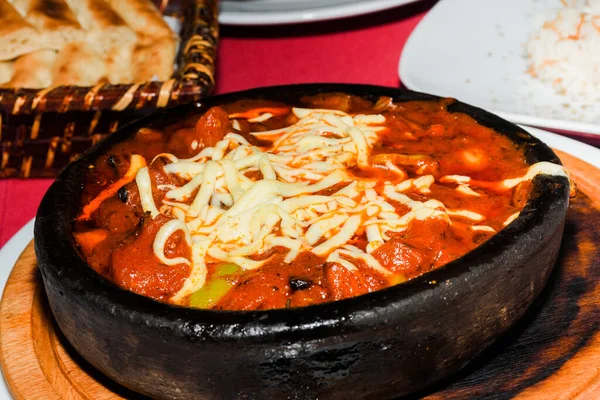 印度菜 传统的鸡肉咖哩 上面有土豆 红辣椒 在白色木制背景的粘土锅上 垂直方向 复制空间 — 图库照片