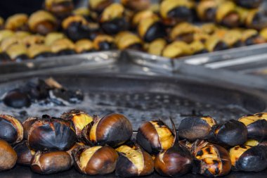 İstanbul, Türkiye 'de bir sokak tezgahında kestane kızartıyorum. Seçici odaklanma. Kış mevsiminde geleneksel sokak yemekleri.