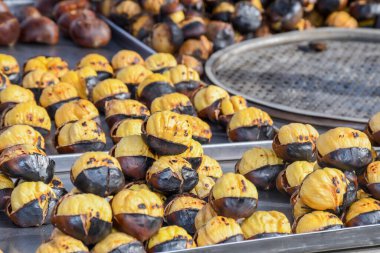 İstanbul, Türkiye 'de bir sokak tezgahında kestane kızartıyorum. Seçici odaklanma. Kış mevsiminde geleneksel sokak yemekleri.