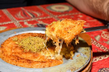 Fıstık tozlu Türk tatlısı. Kunafa, kaday fıstıklı pudra ve peynirli şeker şurubu. Taze pişmiş, eritilmiş peynir ve üstünde fıstık tozu. Lezzetli.