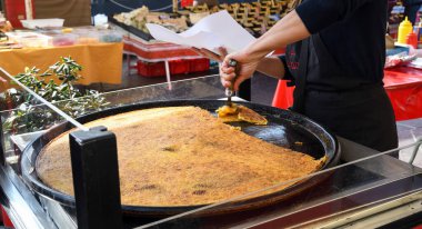 Nice, Fransa, 25 Şubat 2020: Büyük bir tabak Farinata ya da Cecina ya da Torta di ceci mayasız krep ya da Ceneviz kaynaklı nohut krepi ahşap fırında pişirilmiş, soka satılık.