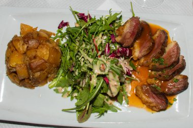 Geleneksel ördek filetosu, az pişmiş, Fransız restoranında salatayla servis ediliyor. Orijinal otantik tarif, üstüne portakal sosu sosu.