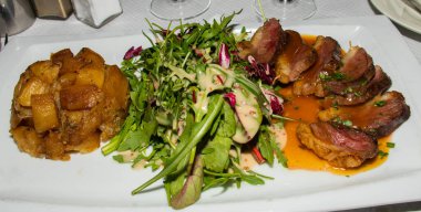 Geleneksel ördek filetosu, az pişmiş, Fransız restoranında salatayla servis ediliyor. Orijinal otantik tarif, üstüne portakal sosu sosu.