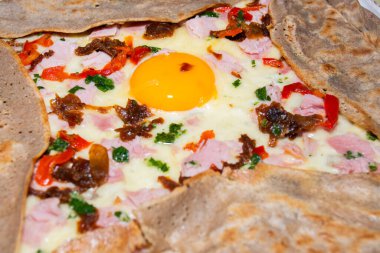 Jambonlu krep galeti, avokado, yumuşak beyaz peynir ve beyaz tabakta haşlanmış yumurta. Dilimlenmiş sarı peynir, pastırma, vişneli domates, yeşil salata ve yanında krep yığını. Üst görünüm