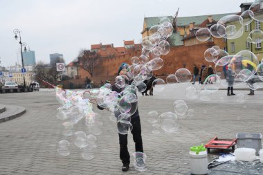 Varşova şehir merkezinde sabun balonları yapan bir adam. Eski şehir, eski kasaba, kış boyunca.