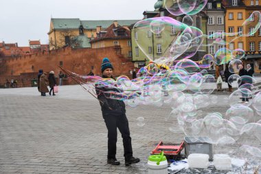 Varşova şehir merkezinde sabun balonları yapan bir adam. Eski şehir, eski kasaba, kış boyunca.