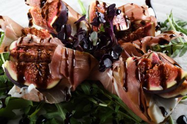 Geleneksel İtalyan salatası incirli jambonlu jambon ya da ince dilimlenmiş jambonlu jambonlu İtalyan salatası İtalyan restoranında beyaz tabakta servis edilir.