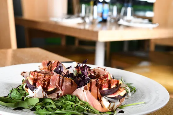 Stock image Traditional Italian salad made with figs, Prosciutto dry-cured ham or Parma ham thinly sliced prosciutto crudo served on a white plate in an Italian Restaurant