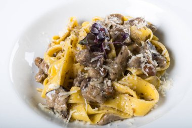 Porcini mantarlı ve mantar kokulu taze pappardelle makarna. İtalyan usulü ve baharatlı geleneksel İtalyan yemeği. Parmesan ve mozzarella peyniri sosu. Restoran masası ayarı.